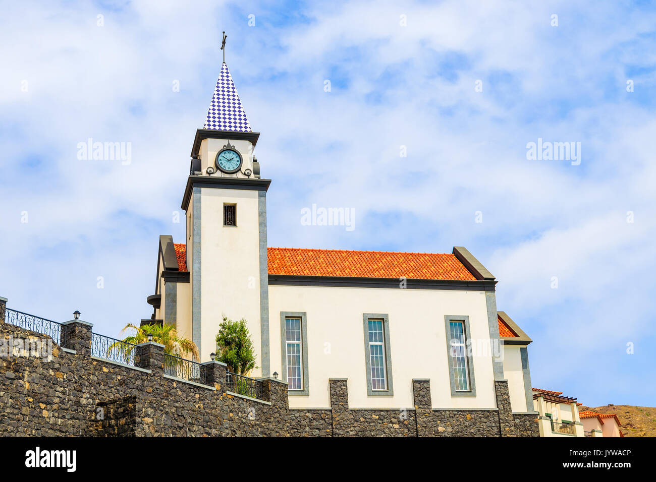 Edificio de la Iglesia contra el cielo azul con nubes blancas en la costa de la isla de Madeira, Portugal Foto de stock