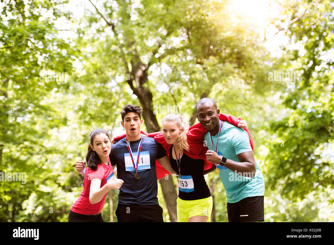 Grupo de jóvenes colocar amigos feliz después de terminar la carrera. Foto de stock