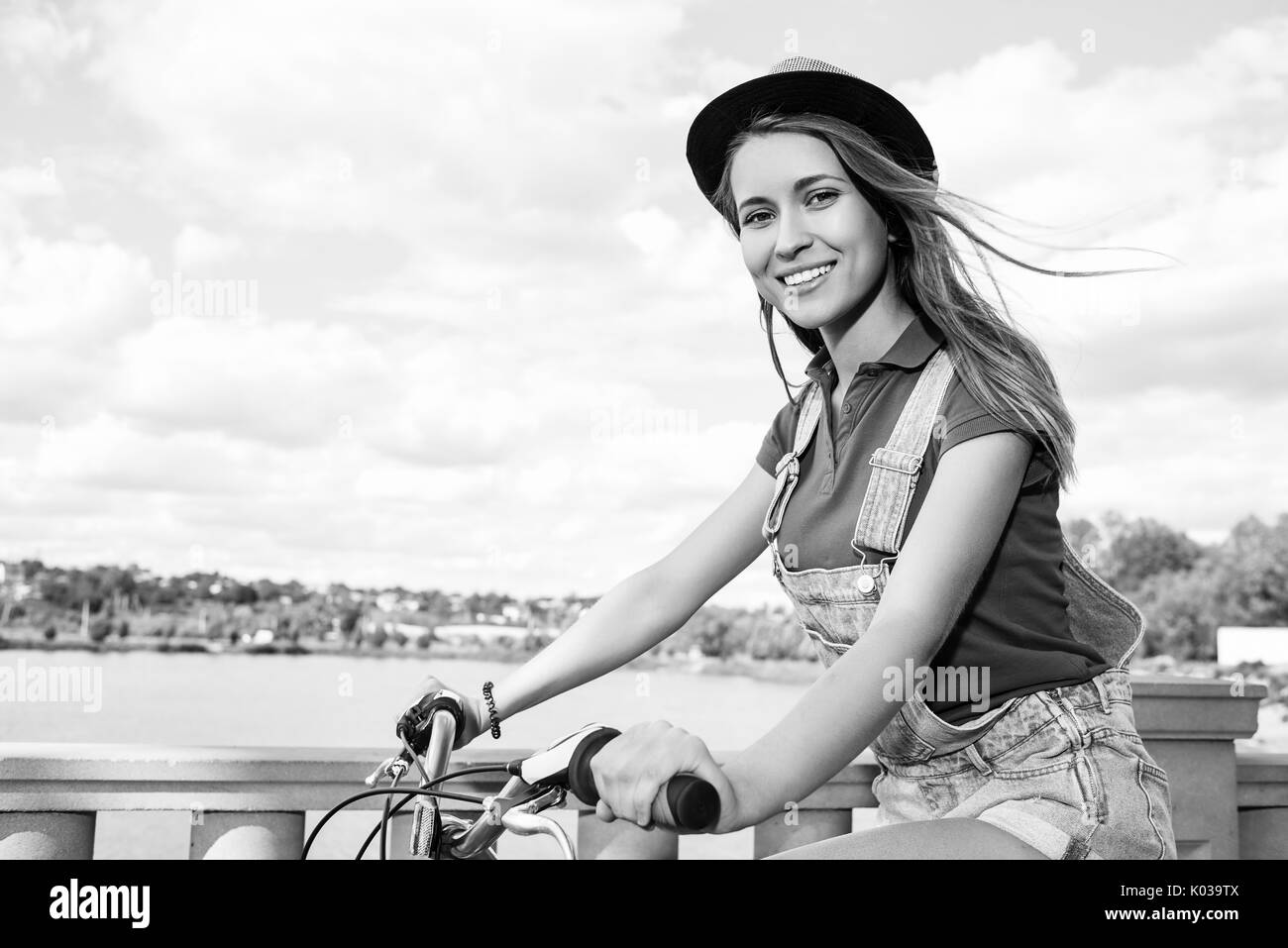 Hermosa mujer joven con su bicicleta en el parque Foto de stock
