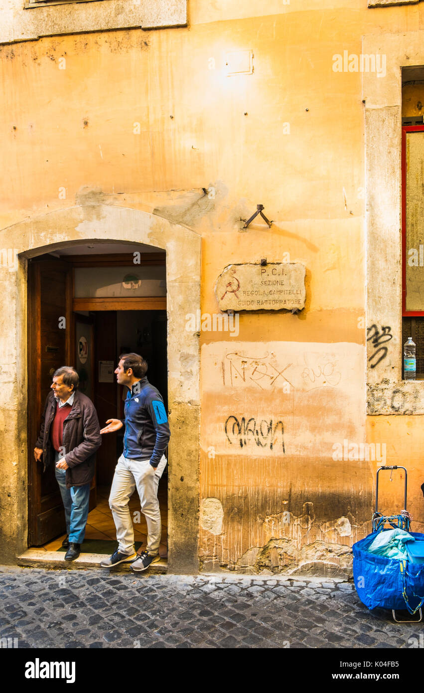 Dos hombres tener una conversación en la portada de la sección local de PCI en el centro histórico de la ciudad de Roma. Foto de stock