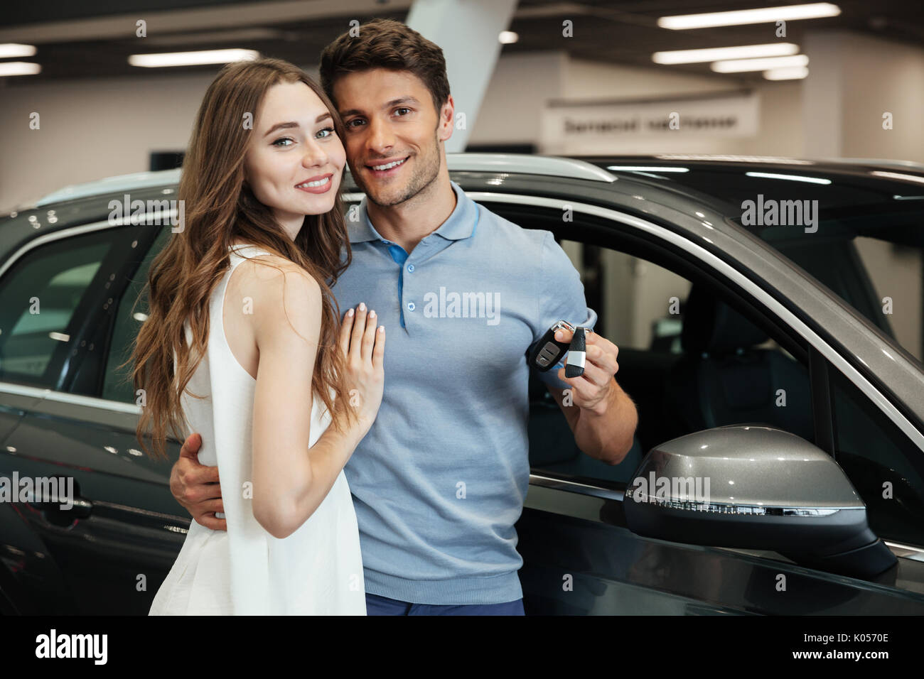 Foto De Señorita Parado Cerca Del Coche Con El Novio En El Concesionario De Automóviles Mirando 