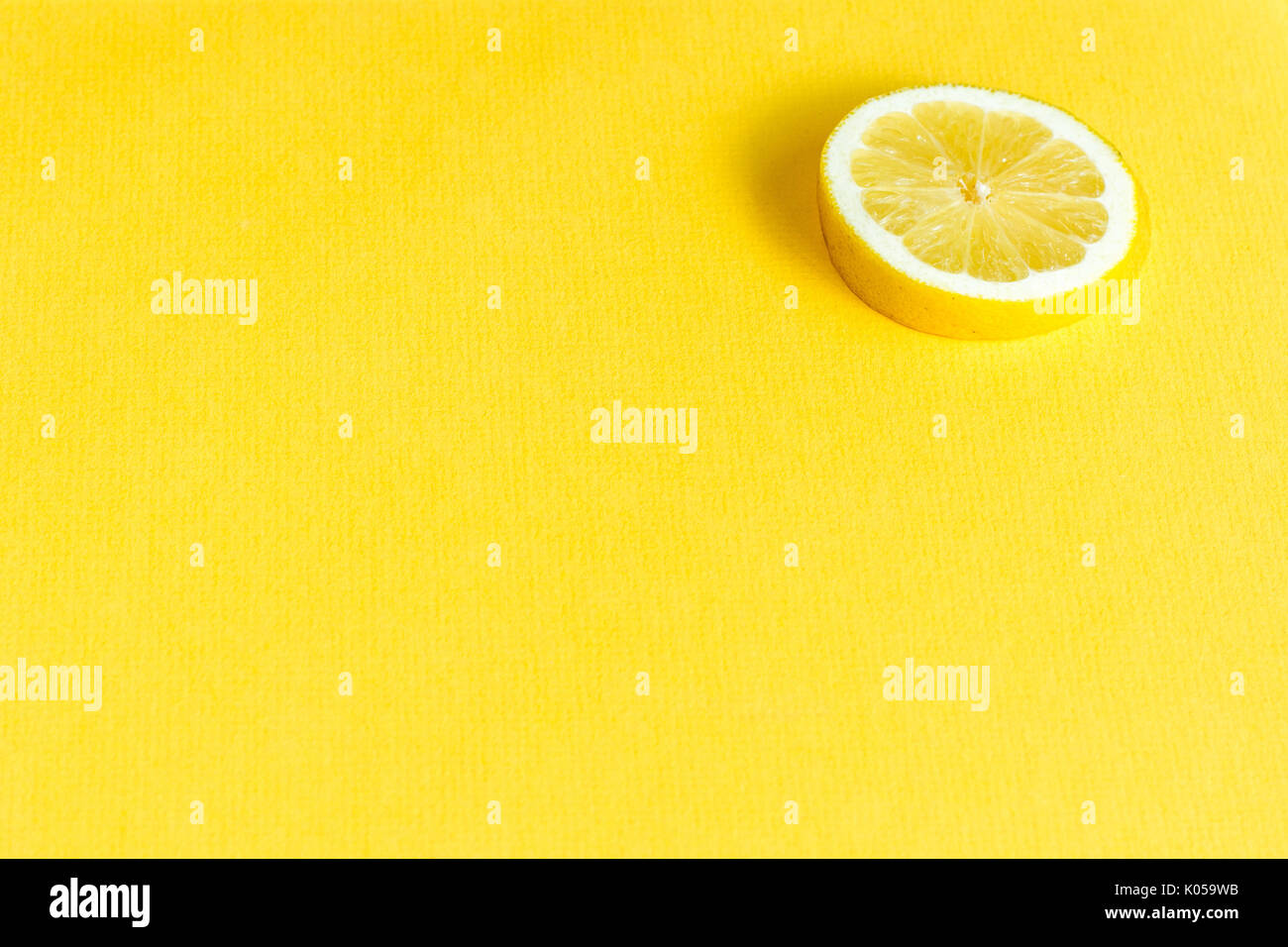 Una rodaja de limón sobre amarillo minimalismo junta mat Foto de stock