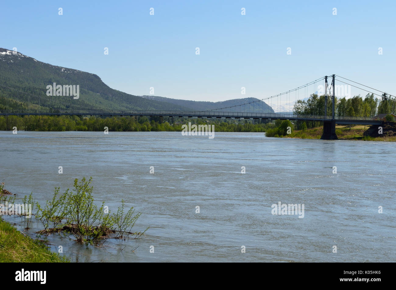 Río inundado en muelle debajo de puente Foto de stock