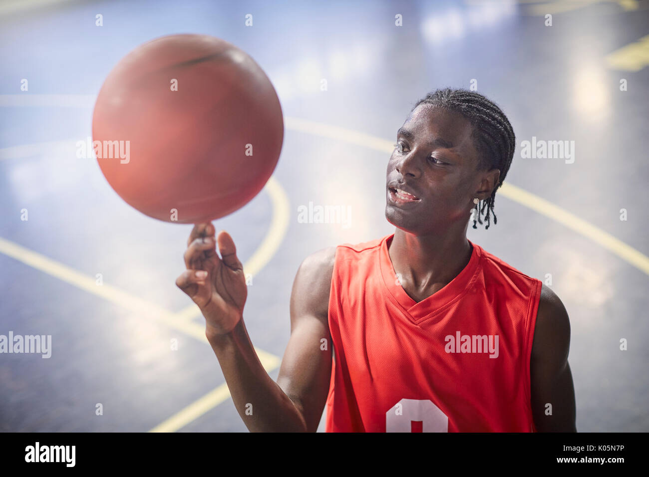 Joven jugador de baloncesto masculino de baloncesto de hilado en la corte Foto de stock