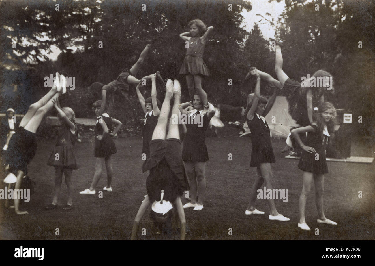 Las colegialas practicar gimnasia música (proporcionado por un piano vertical). Fecha: circa 1920 Foto de stock