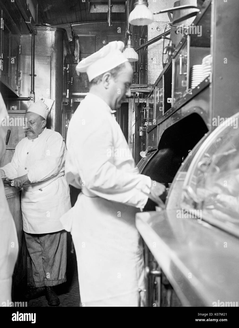 Los chefs cocinar en la cocina de un lujoso tren overland limitado en los Estados Unidos Fecha: circa 1910 Foto de stock