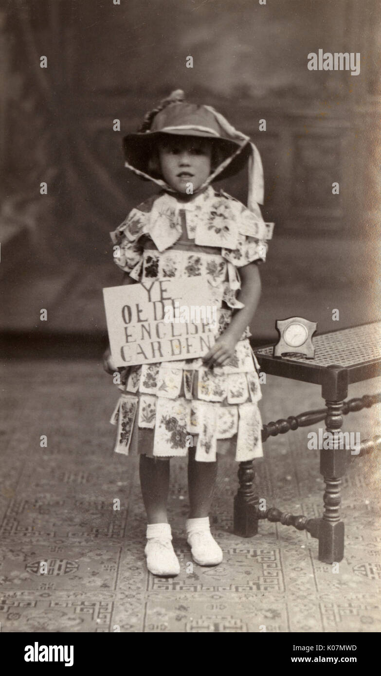 Retrato de estudio, Little Girl en Ye Olde English Garden traje (según el anuncio que sostiene). Fecha: circa 1910s Foto de stock