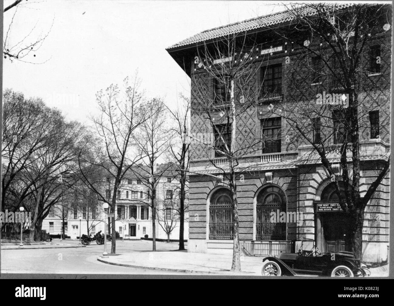 Una calle de Baltimore con un arbolado las aceras y dos grandes y adornados edificios; cada una con un coche delante; un edificio (a la derecha) para alquiler, con tres historias, telas trabajos de piedra y arcos de primera historia windows y entrada, Baltimore, Maryland, en 1910. Esta imagen es de una serie documenta la construcción y venta de casas en el Roland Park/Guilford barrio de Baltimore, un suburbio de tranvía y una de las primeras comunidades planificadas en los Estados Unidos. Foto de stock