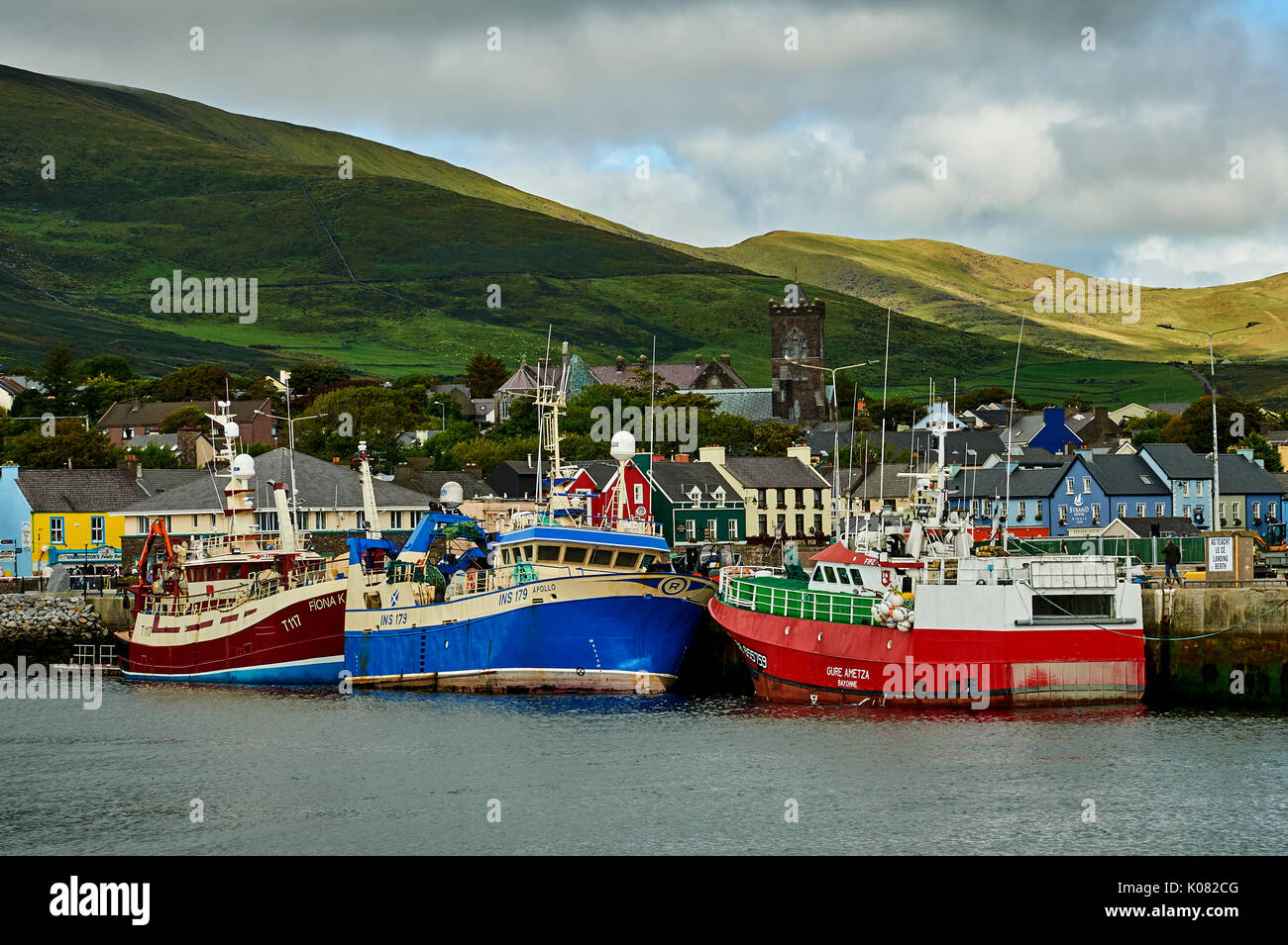 Dingle, Condado de Kerry en la República de Irlanda y una colección de barcos de pesca están amarrados en el pequeño puerto de pescadores. Foto de stock