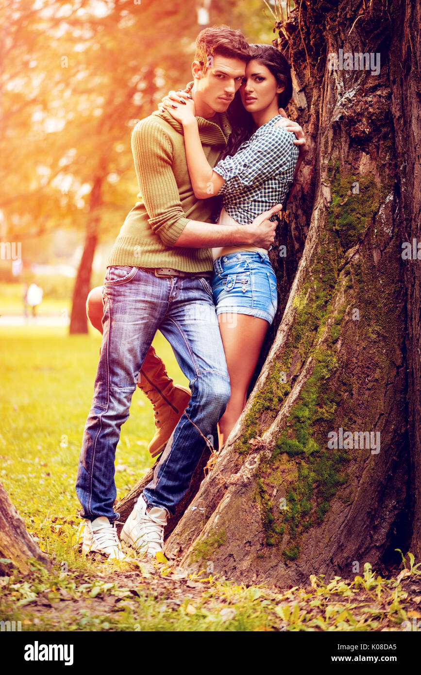 Hermosa hermosa pareja disfrutando en sunny park en colores de otoño. Foto de stock