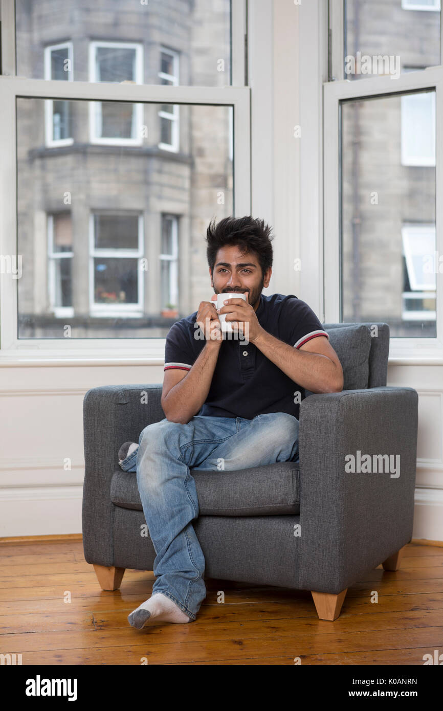 Retrato de un hombre asiático de moda en casa. Hombre indio relajado en casa.s Foto de stock