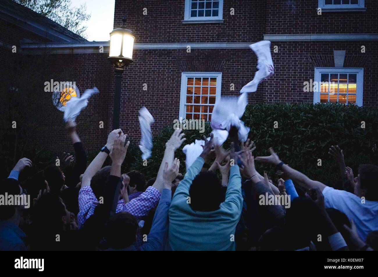 Una multitud de estudiantes universitarios llegar a sus manos en alto a fin de try y catch camisetas que están cayendo desde arriba, 2014. Cortesía de Eric Chen. Foto de stock