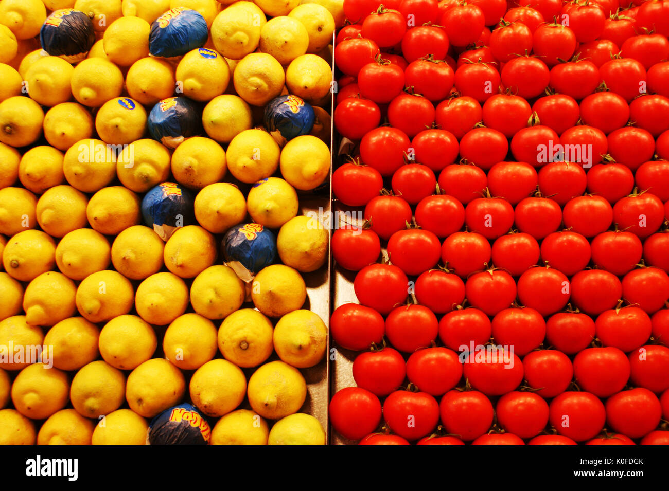 Una muestra de la fruta fresca, los limones en papel enrollado y tomates en un puesto en el mercado de la Boqueria Barcelona España Foto de stock