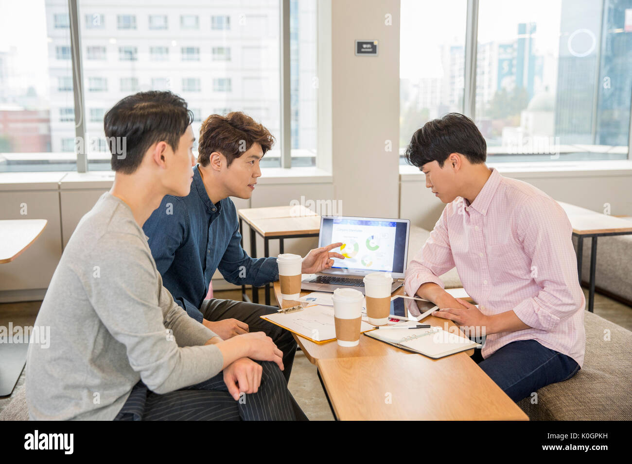 Tres empresarios tras una reunión en la cafetería Foto de stock