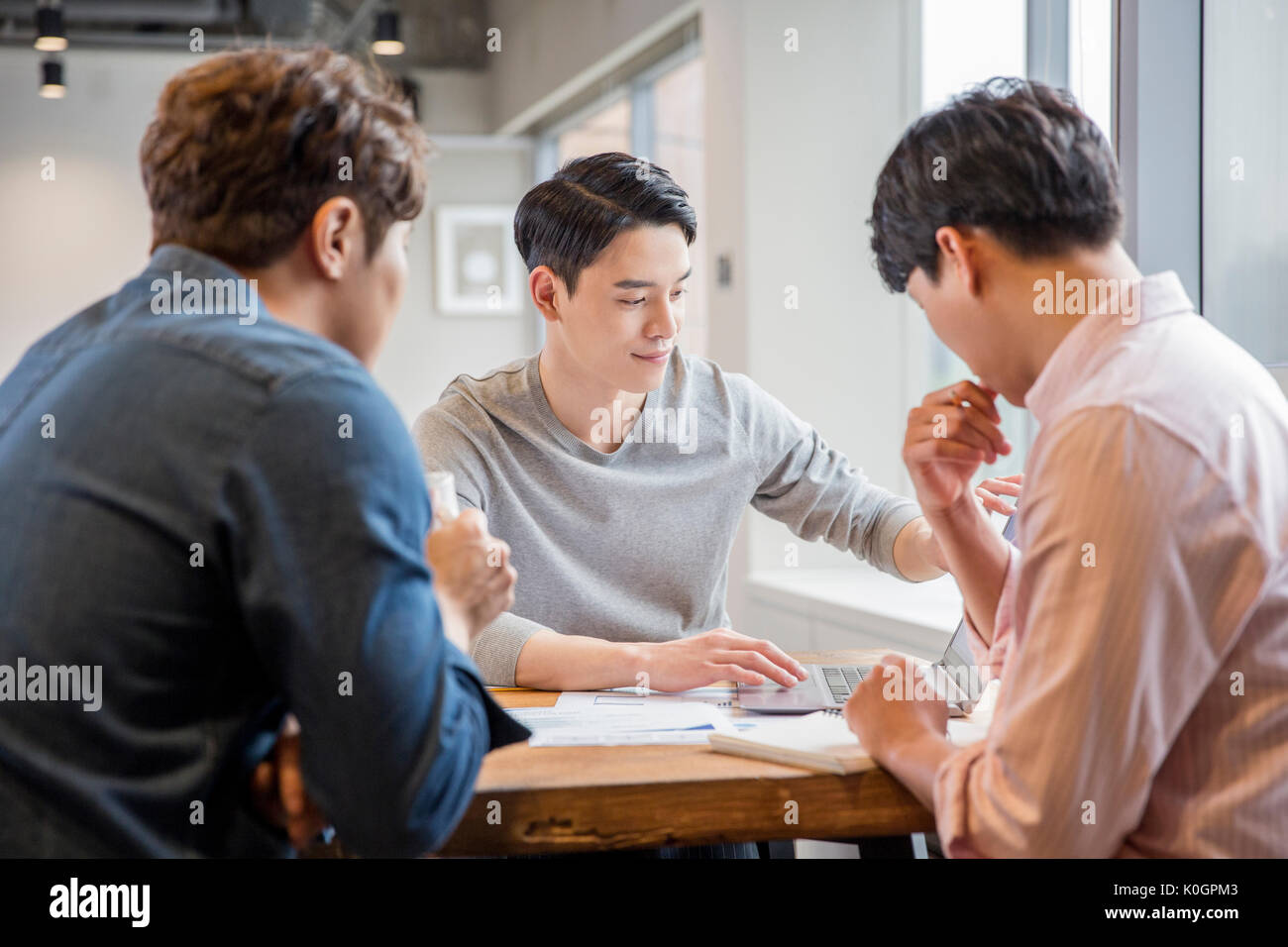 Retrato de tres empresarios sonrientes tener una reunión Foto de stock