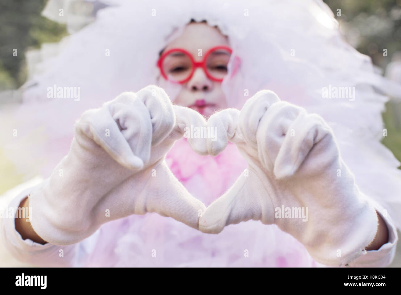 Chica en disfraz de carnaval hace el corazón de los dedos Fotografía de  stock - Alamy
