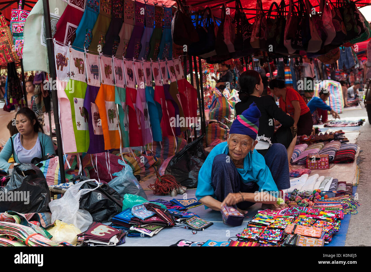 Una anciana de la tribu Hmong hill-vende souvenirs en un mercado nocturno en Luang Prabang, Laos. Foto de stock