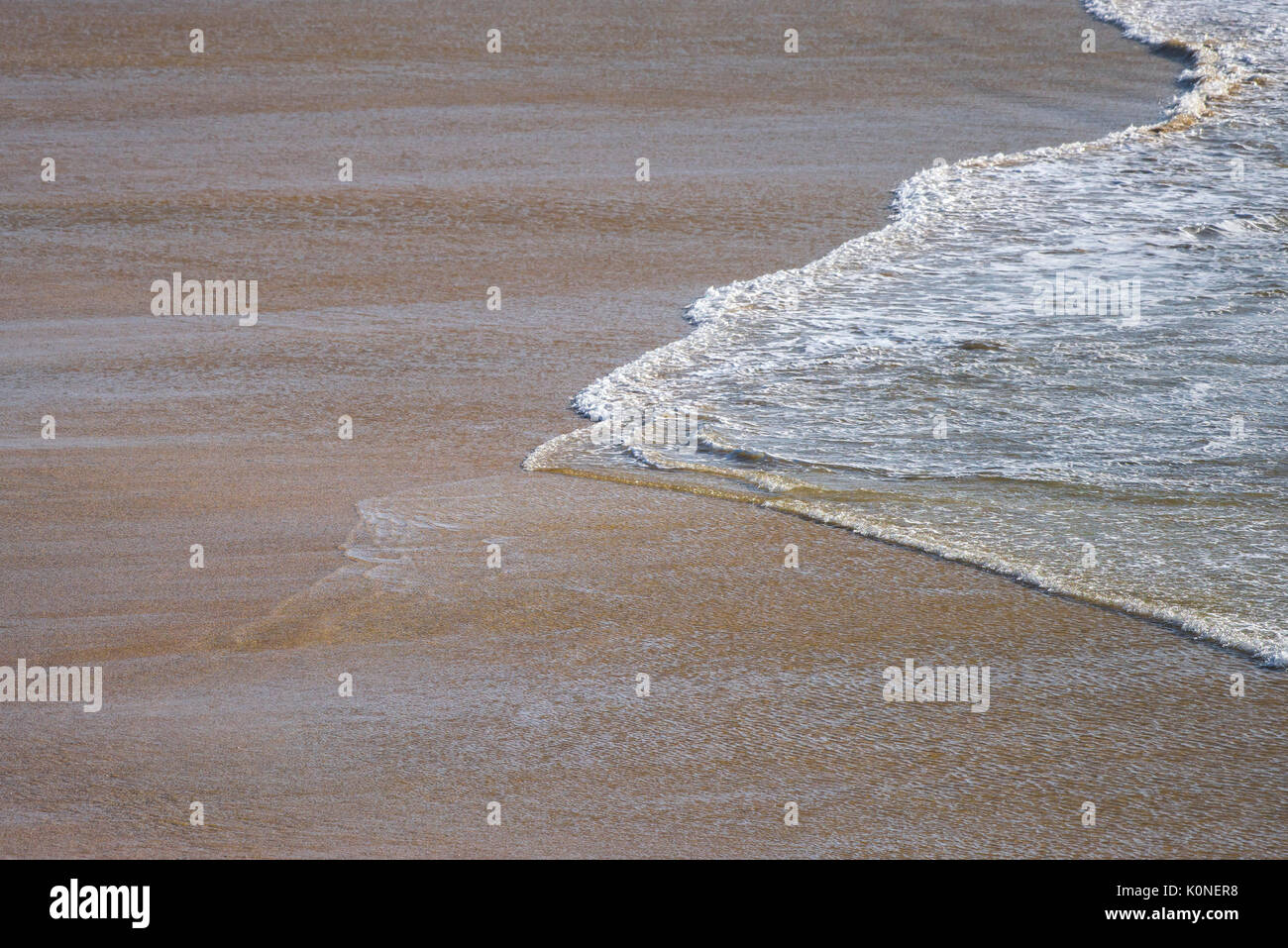 Marea entrante en una playa desierta. Foto de stock