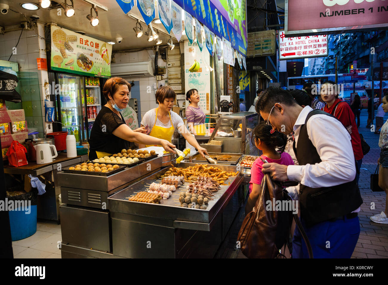 HONG KONG - Julio 11, 2017: Un vendedor callejero que vende aperitivos populares en el mercado nocturno de la calle Fa Yuen en Kowloon. Estos incluyen stinky tofu, intestinos de cerdo Foto de stock