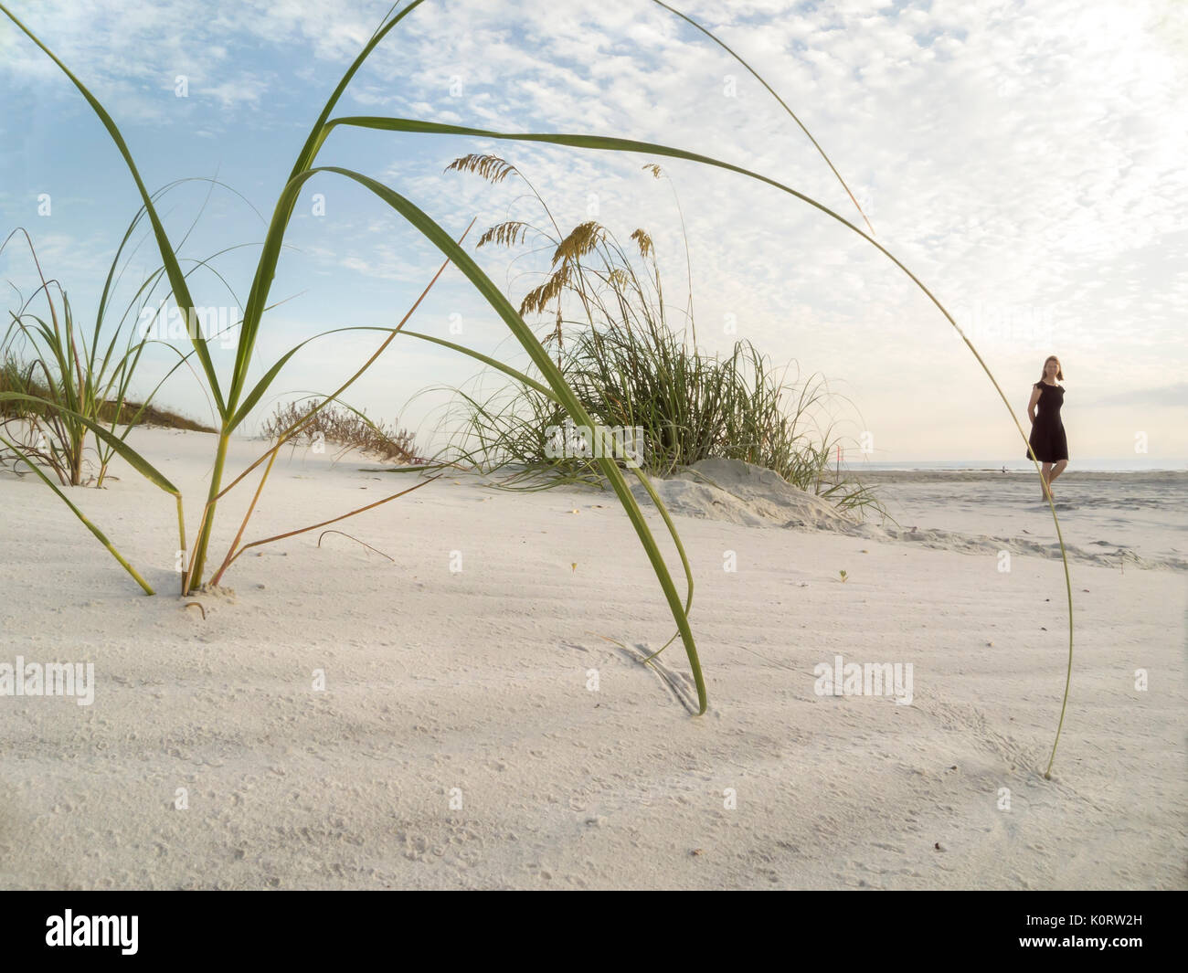 Mujer madura, caminar sobre la playa de arena blanca con mar avena Foto de stock