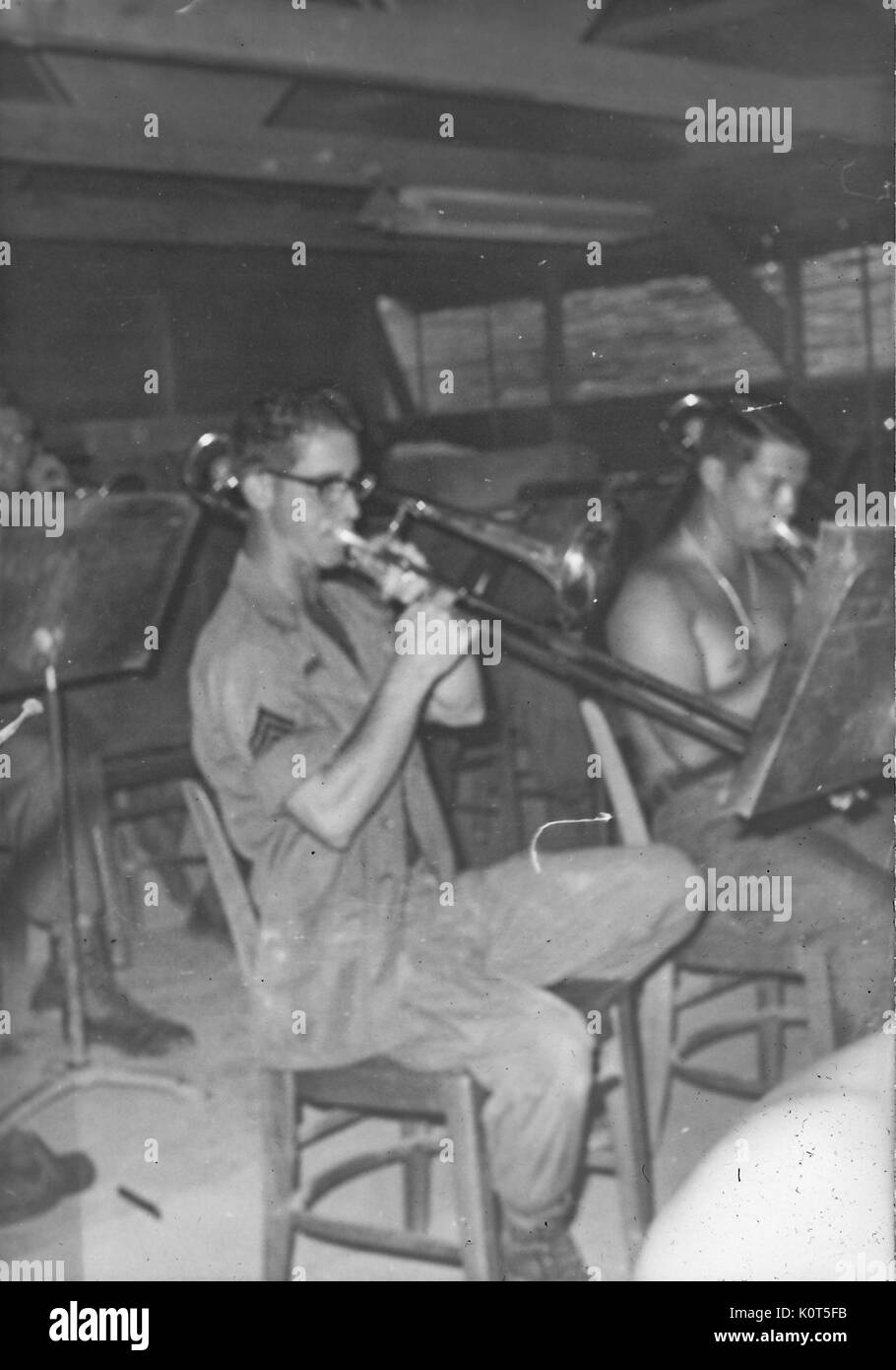 Una fotografía de los miembros del ejército de los Estados Unidos de América Primera División de Infantería de la banda, que están tocando sus instrumentos mientras leyendo partituras dentro de un edificio en la base, Vietnam, 1967. Foto de stock