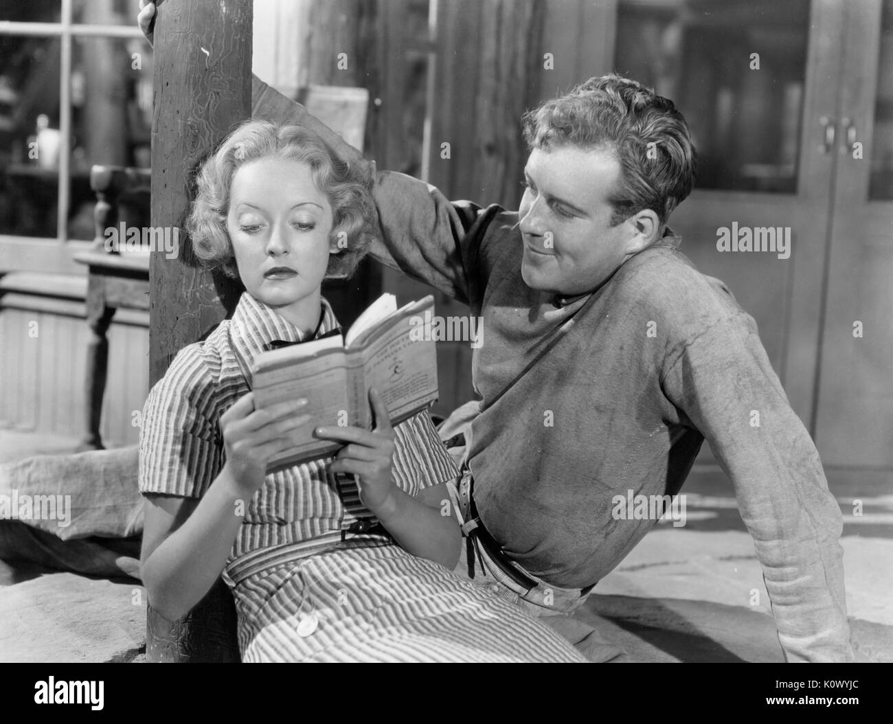 Bette Davis recostado sobre el suelo y leer un libro a un hombre, en una película aún, 1949. Crédito de la foto Smith Colección/Gado/Getty Images. Foto de stock