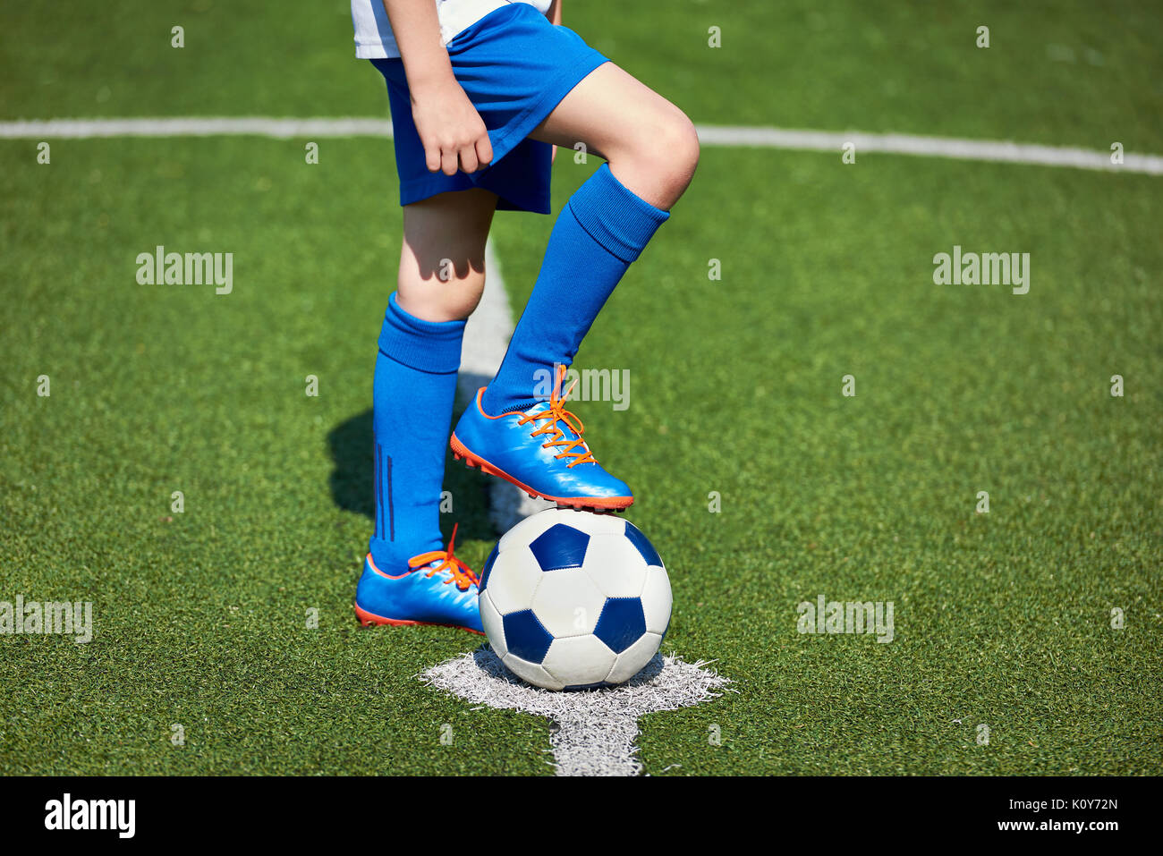 Pie de un jugador de fútbol en una bota en una bola sobre un césped  artificial del estadio Fotografía de stock - Alamy