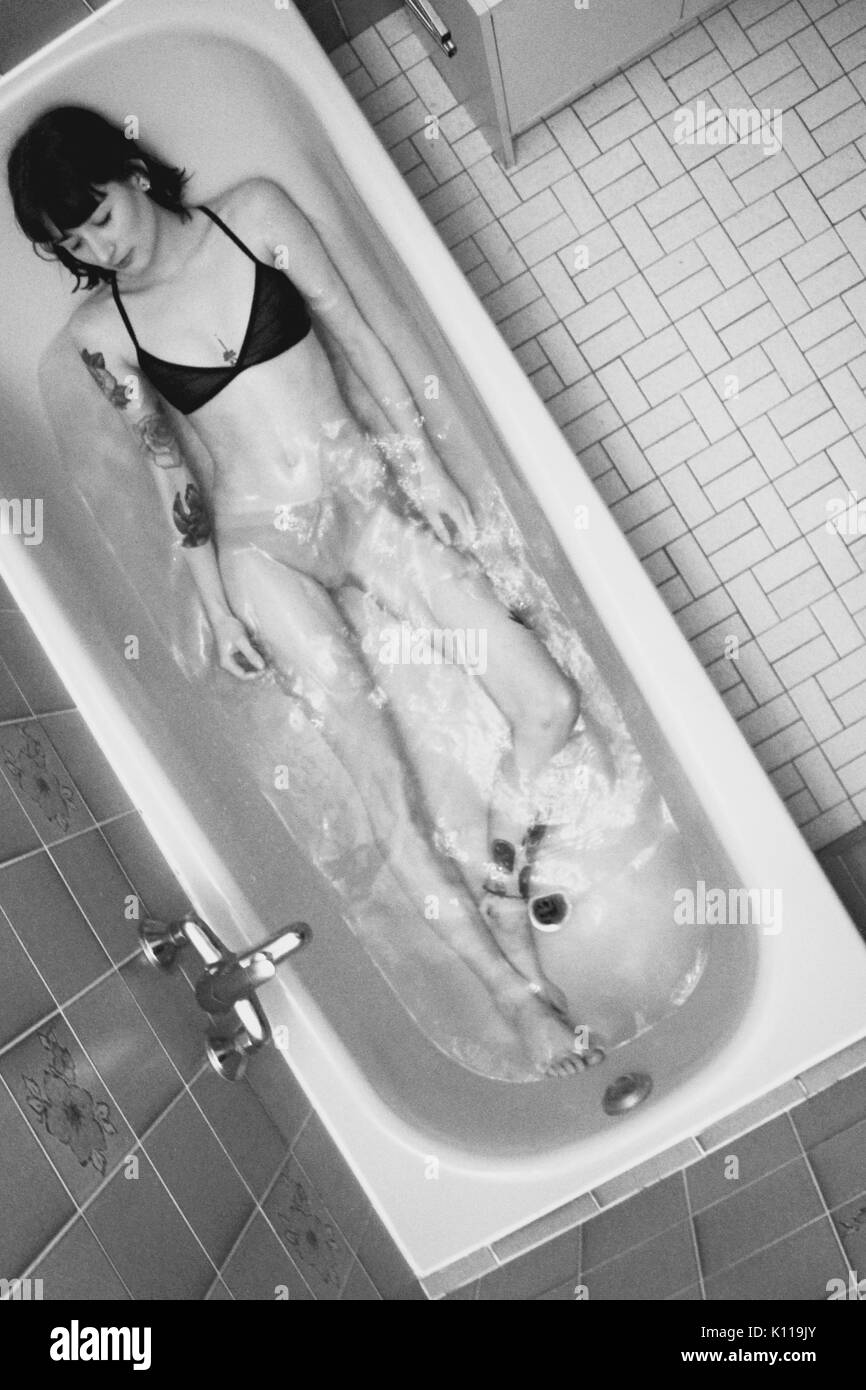 Chica yace en la bañera Foto de stock