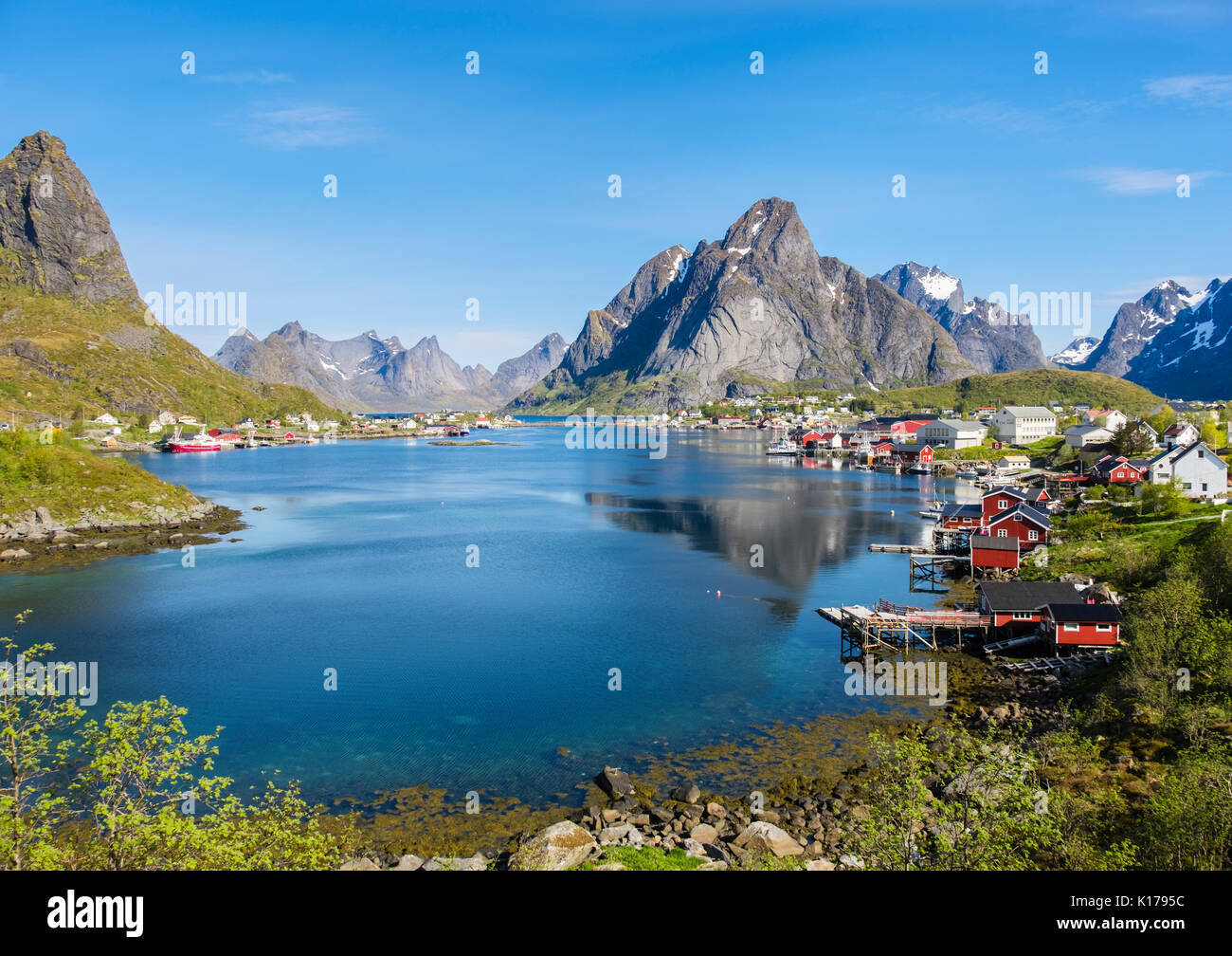 Vista escénica a través de puerto pesquero natural a la montaña en verano. Reine, Moskenes, Moskenesøya, Islas Lofoten, Nordland, Noruega Foto de stock