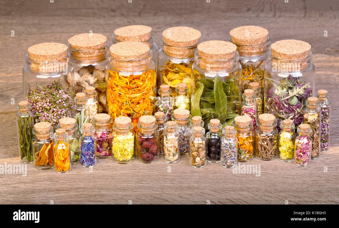 Hierbas curativas en botellas de medicina herbaria en mesa de madera antigua. Foto de stock