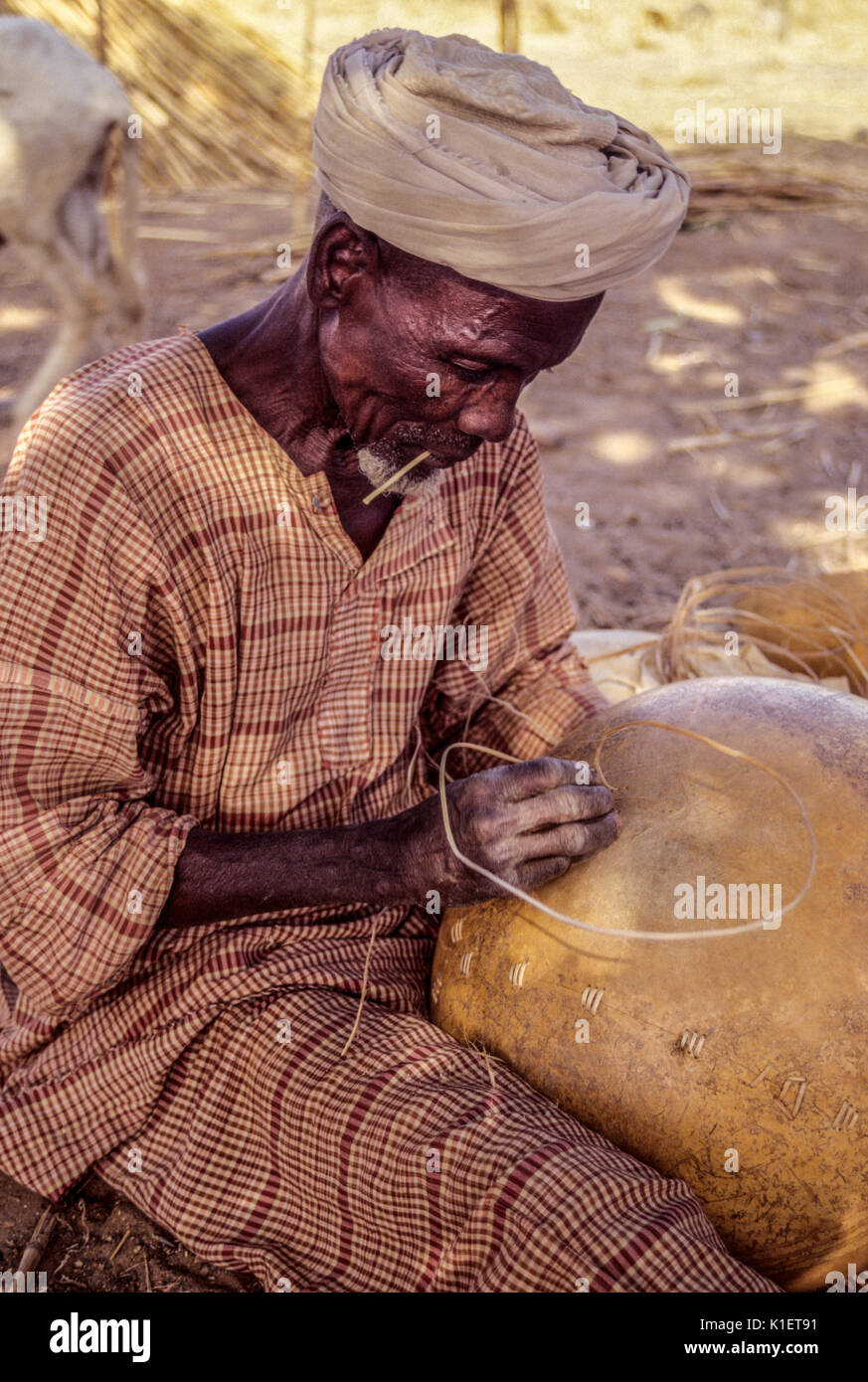 Níger, Delaquara, África occidental. Hombre Sordo estaba arreglando una calabaza. Foto de stock