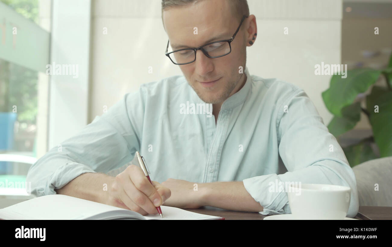 Empresario escribir una lista de tareas en un planificador empresarial Foto de stock