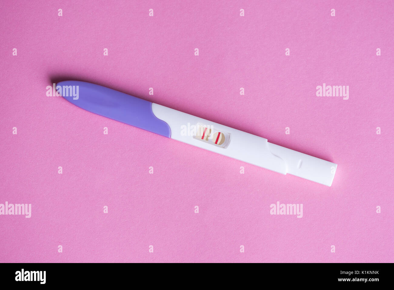 Prueba de embarazo positiva sobre fondo de color rosa Fotografía de stock -  Alamy