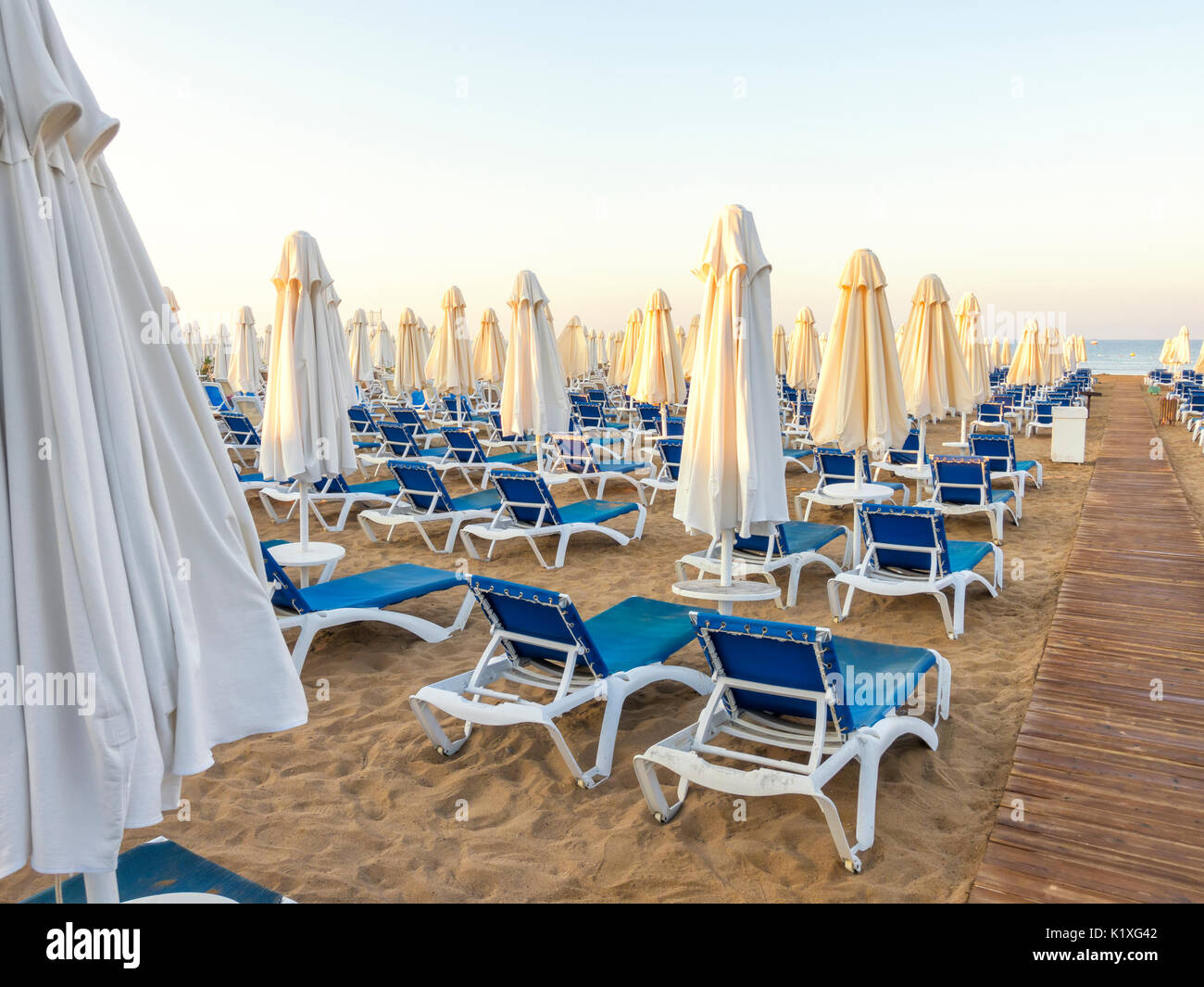 Playa de arena a la mar con sendero de madera, hamacas, sombrillas, Turquía, Side resort Foto de stock