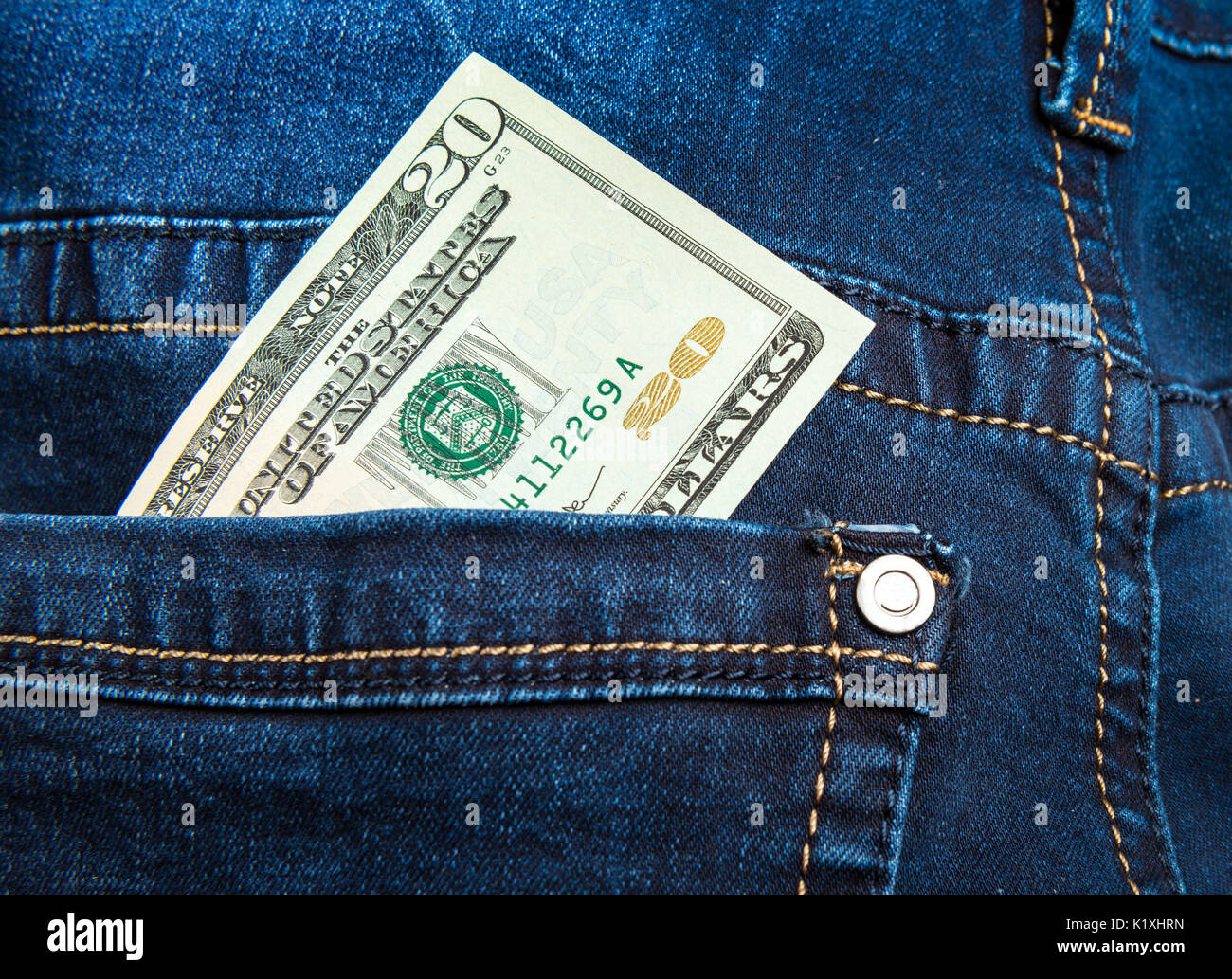 Dinero en el bolsillo de los pantalones vaqueros azules Foto de stock