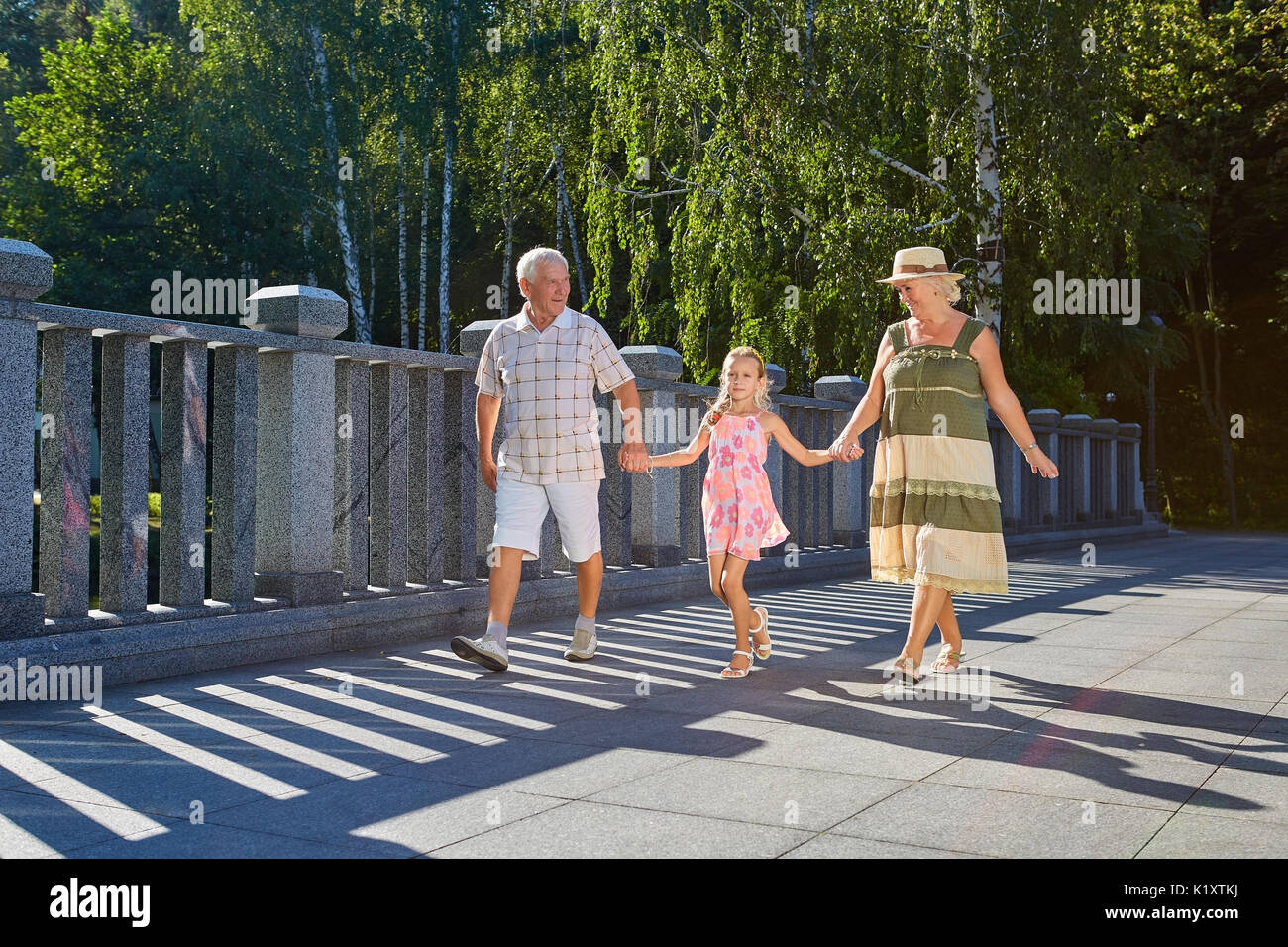 Niños y abuelos, verano. La gente caminando y tomados de la mano. Foto de stock