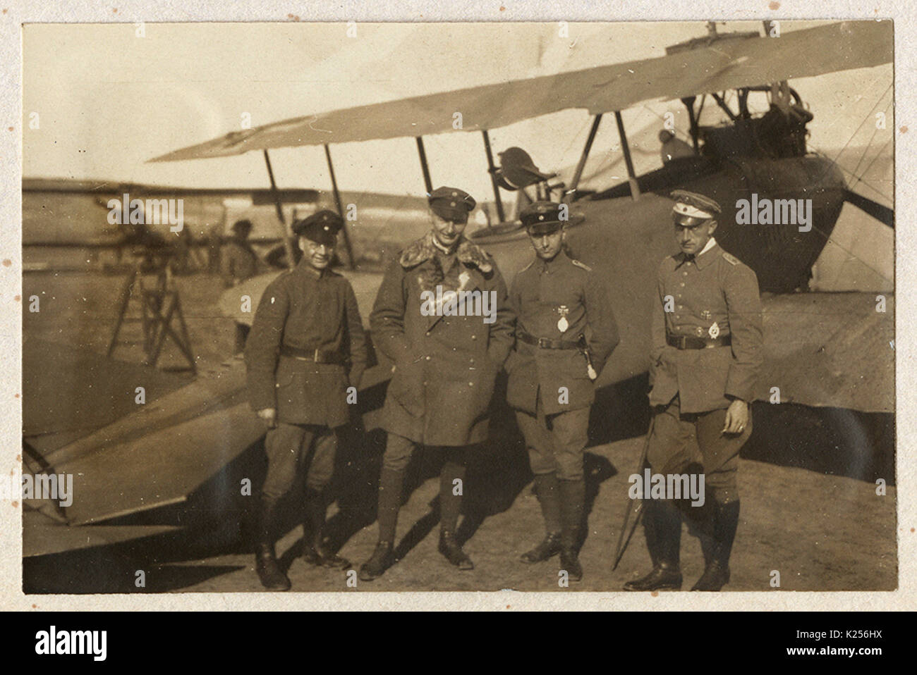 Cuatro pilotos alemanes delante de biplano Foto de stock