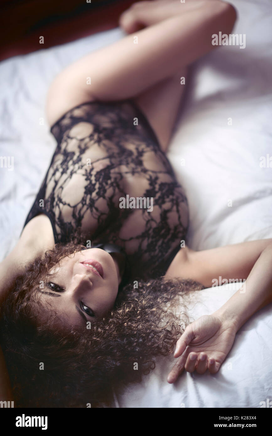 Boudoir sensual retrato de una sonriente joven sexy hermosa mujer acostado  en una cama en ropa interior de Lacy mirando a la cámara Fotografía de  stock - Alamy