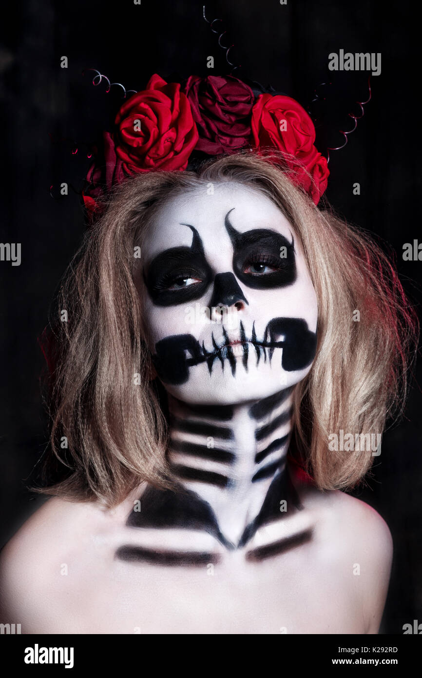 Retrato de mujer joven con miedo halloween maquillaje sobre fondo negro .  hermosa mujer con maquillaje esqueleto Fotografía de stock - Alamy