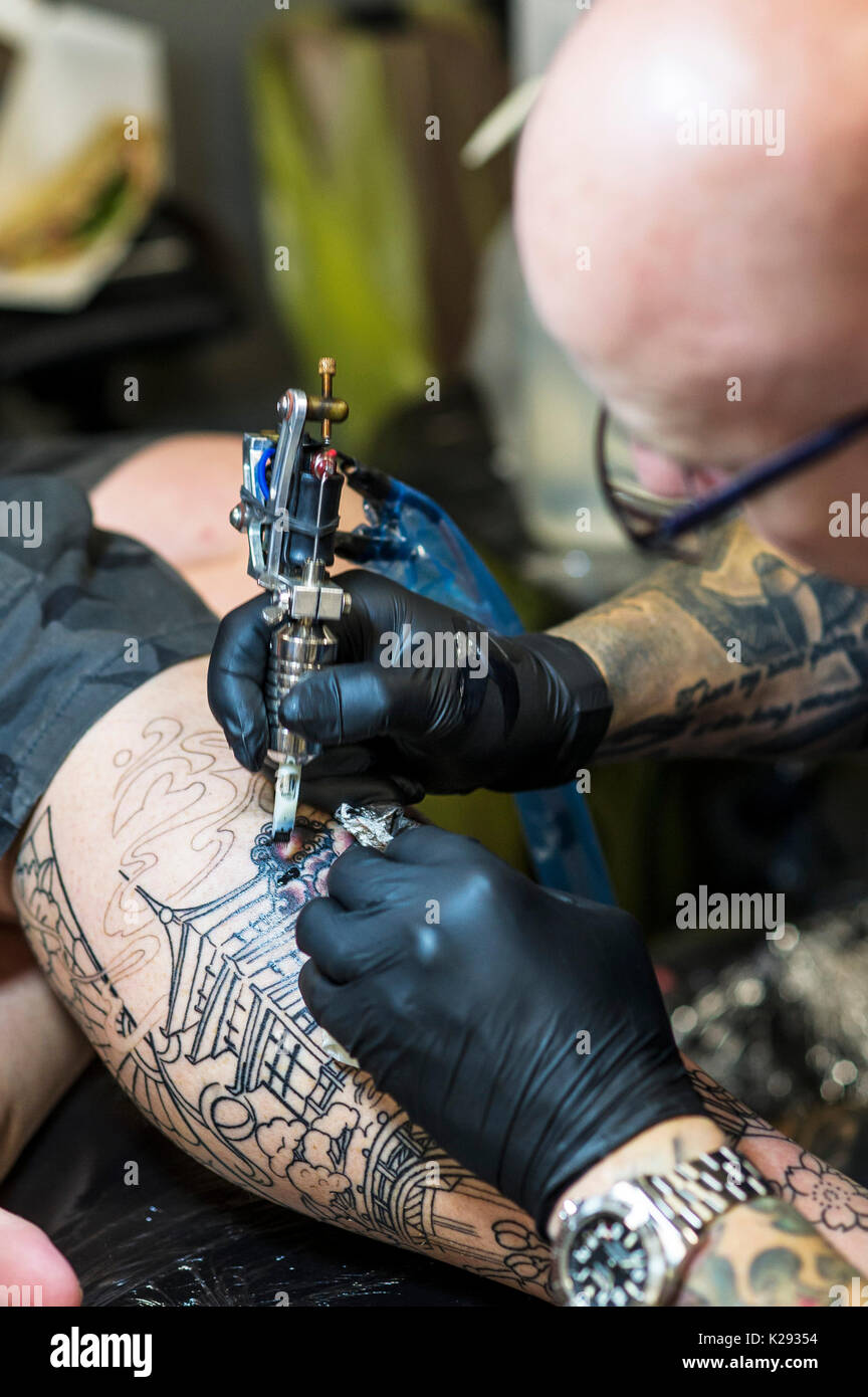 Tatuaje - una visión más cercana del diseño está tatuado en la pierna de un cliente en el Cornwall Tattoo Convention. Foto de stock