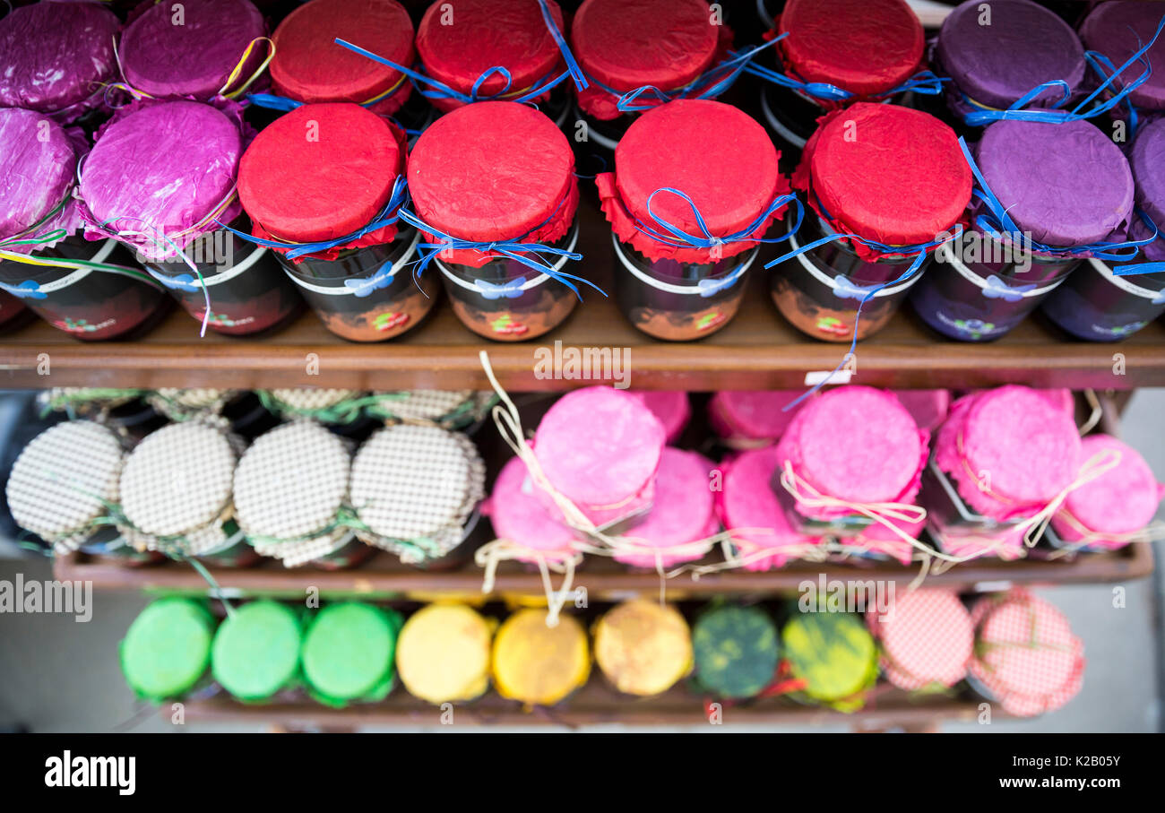Diferentes coloridos botes de mermelada en una estantería desde arriba. Muchas variaciones de la confiture. Foto de stock