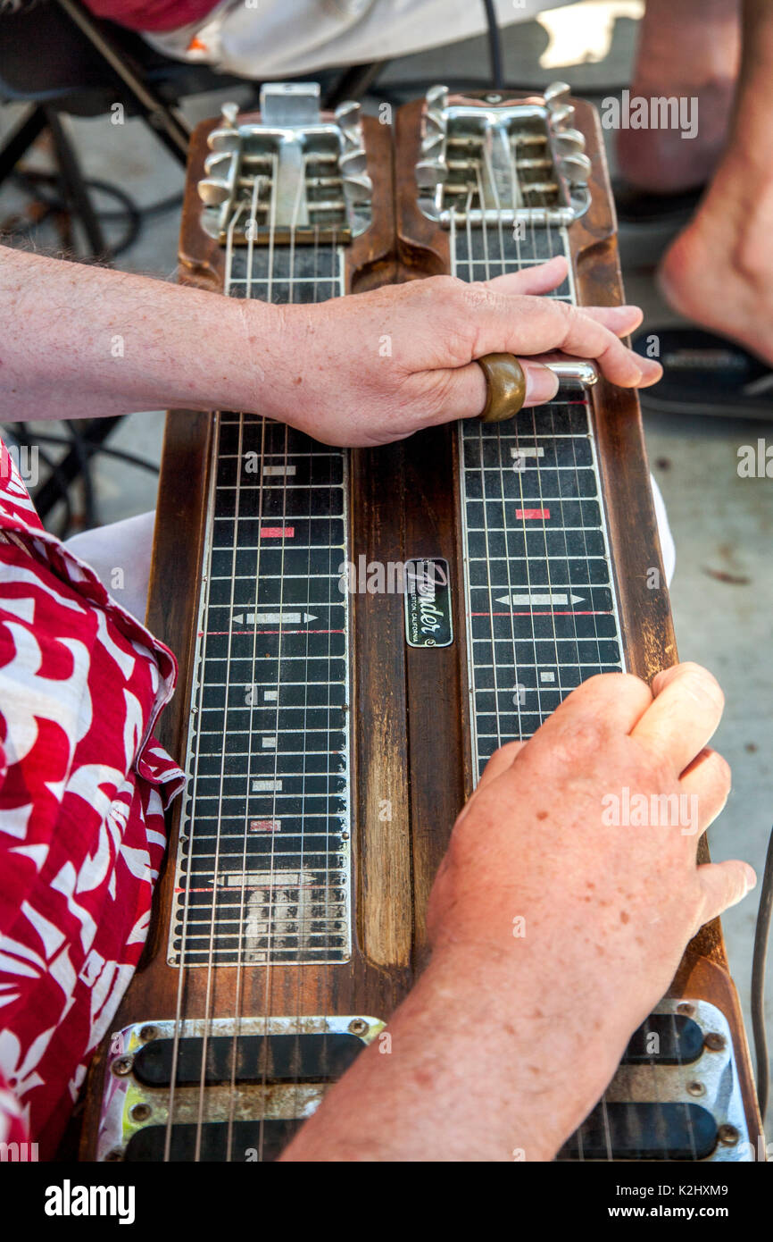 Un músico juega un doble cuello lap steel guitarra hawaiana en un festival  comunitario en Huntington Beach, California. Nota slider en jugador del  pulgar Fotografía de stock - Alamy