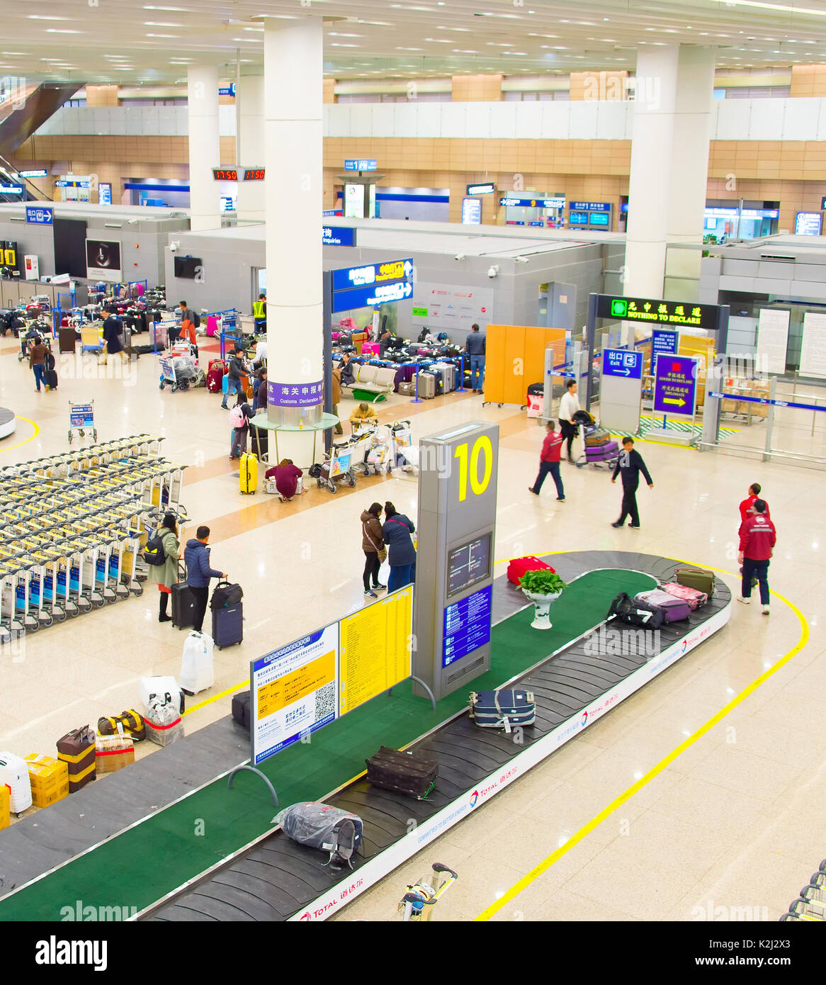 SHANGHAI, China - DEC 26, 2106: la gente en el aeropuerto de Shanghai Pudong llegada contador de inmigración. El aeropuerto de Pudong es un gran cubo de aviación de China Foto de stock