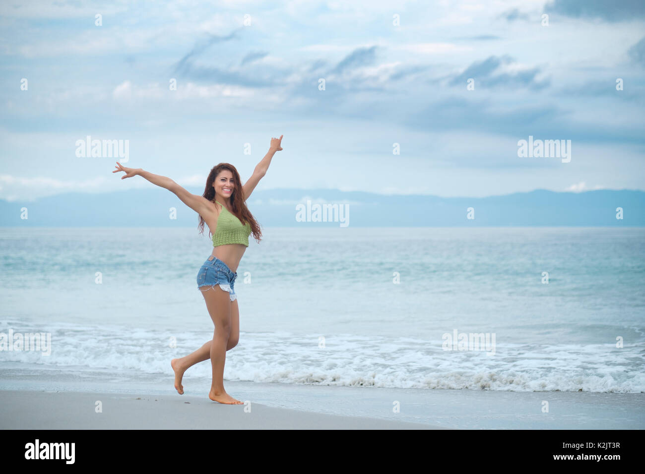 Mujer Hispana feliz disfrutando del paseo de la playa Foto de stock