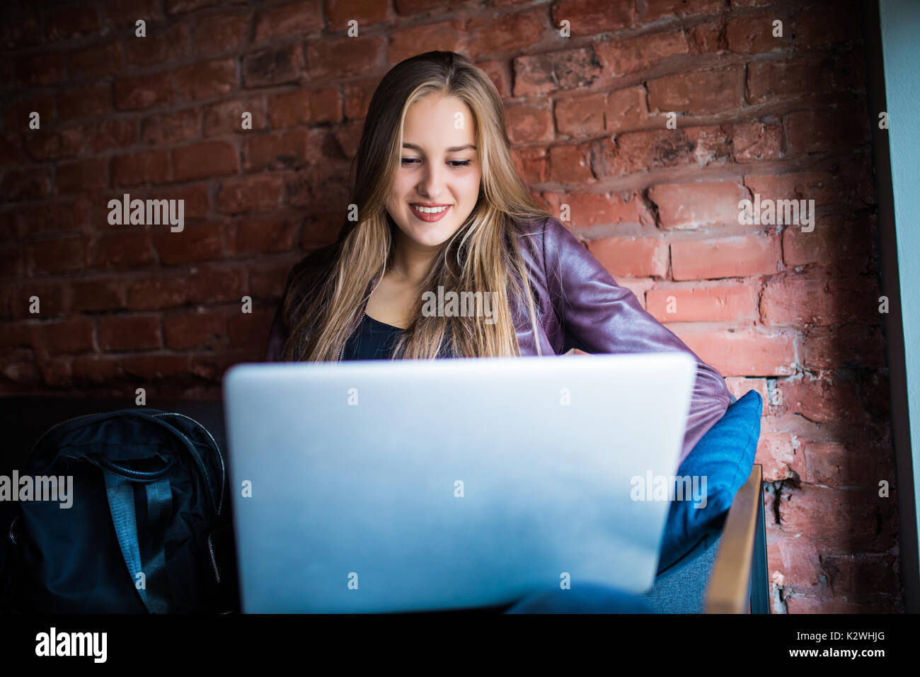 Joven y bella mujer de Freelancer utilizando equipo portátil sentado en la mesita de café. Chica sonriente feliz trabajando en línea o estudiando y aprendiendo mientras usa N Foto de stock