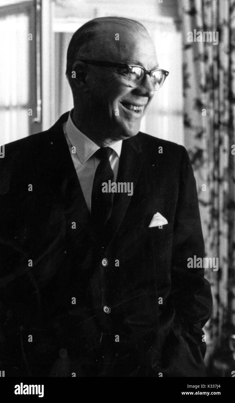 Cándido retrato de media longitud de la American Educational administrador y Presidente de la Universidad Johns Hopkins Milton S. Eisenhower, de pie y sonriente, 1965. Foto de stock