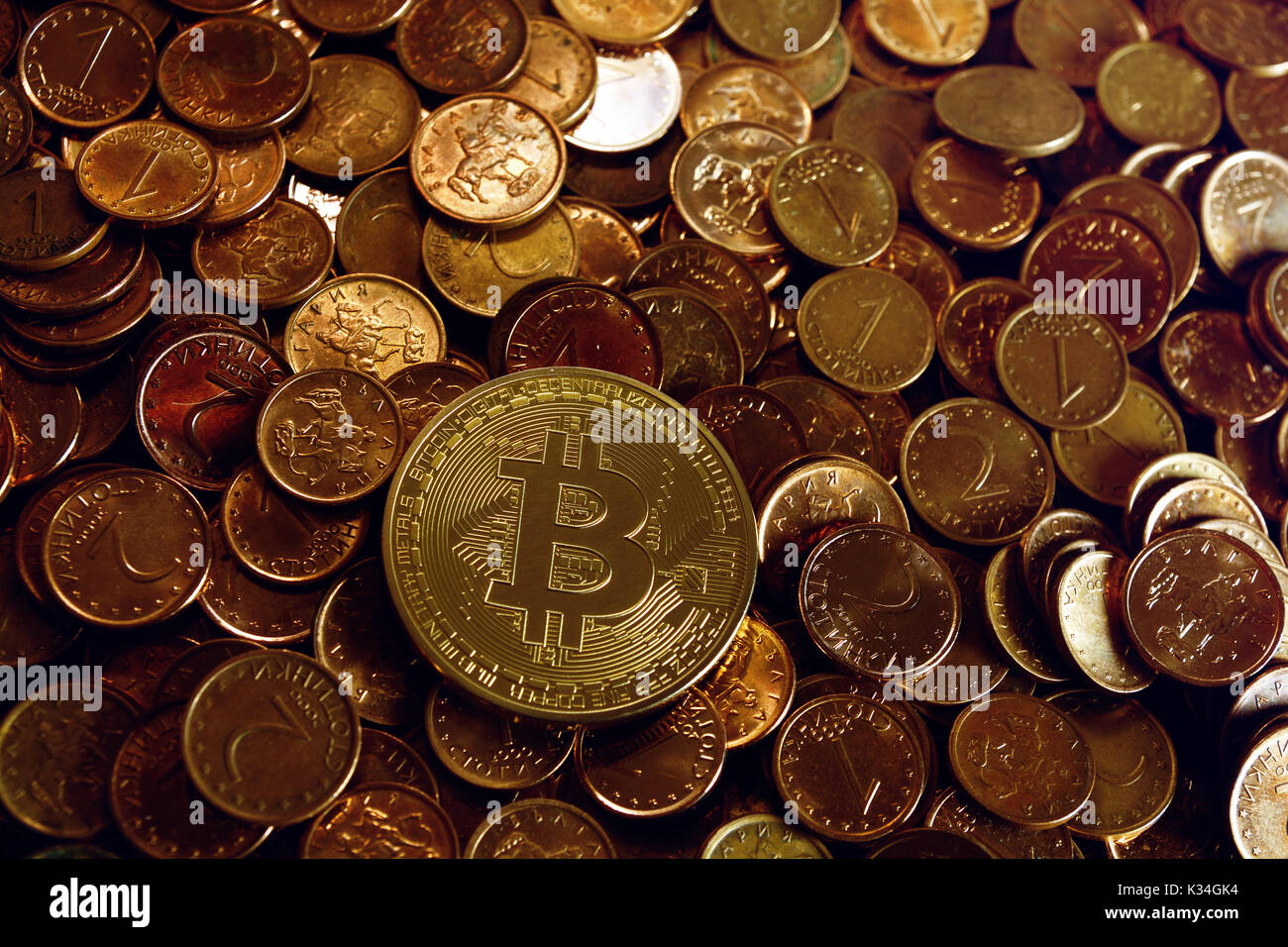 Golden bitcoin a una pila de monedas de céntimo Foto de stock