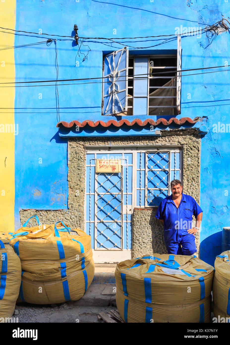 Cubal trabajador construcción plantea delante de coloridas casas residenciales en proceso de remodelación y construcción en regla, La Habana, Cuba Foto de stock