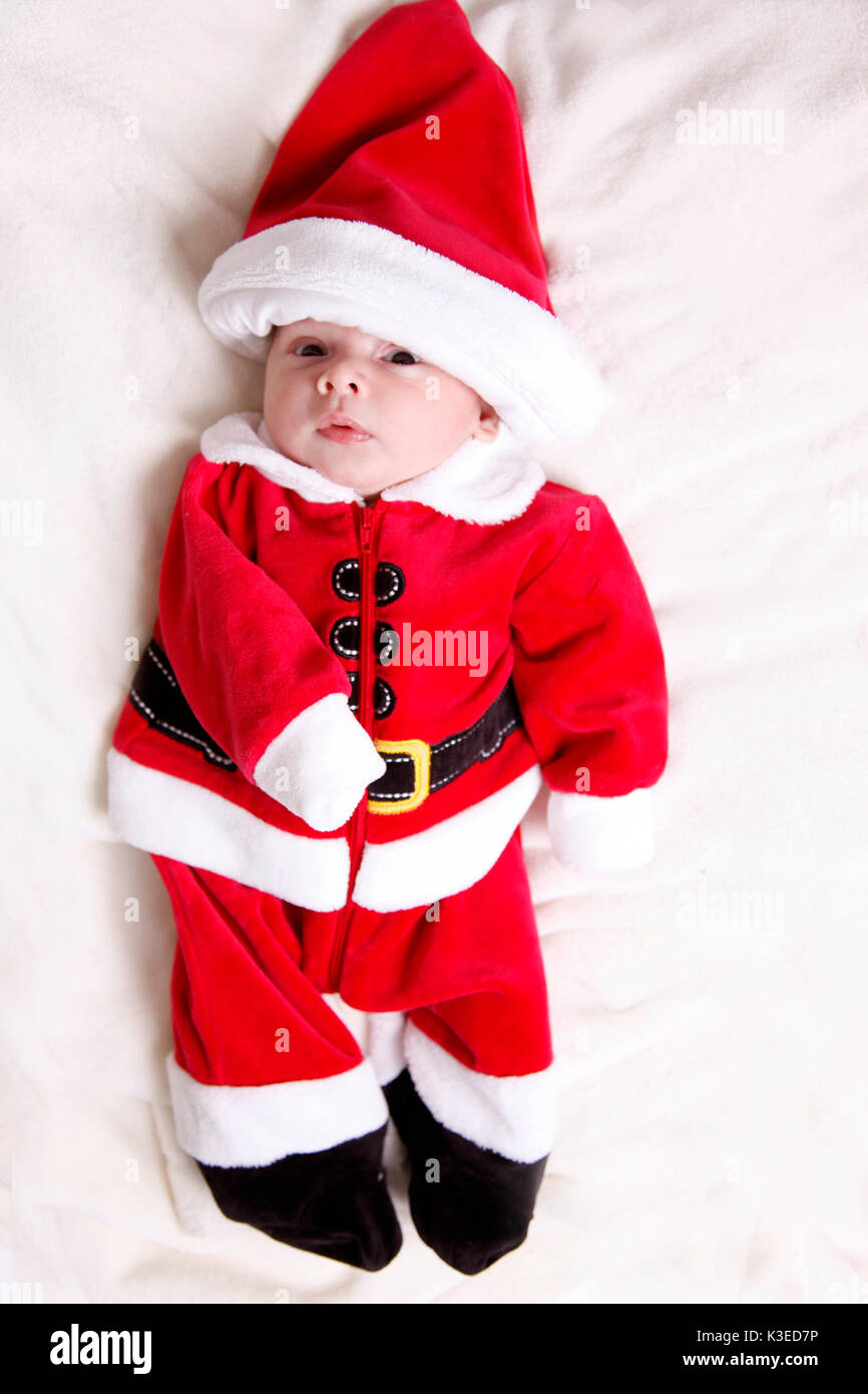 Un bebé recién nacido está vestido con un traje rojo y blanco de santa con  sombrero en studio Fotografía de stock - Alamy