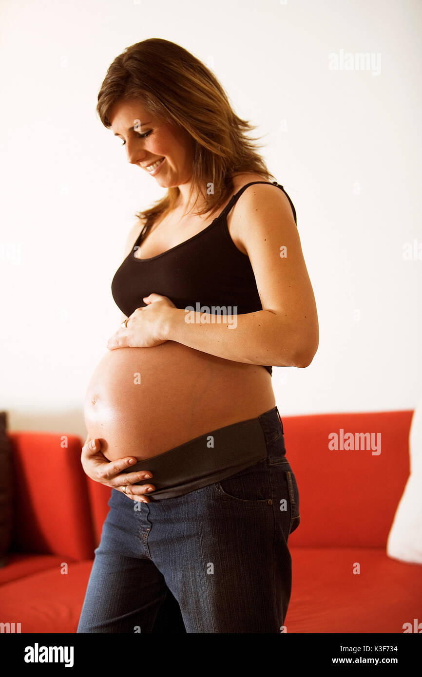 Joven Embarazada mantiene el abdomen Foto de stock